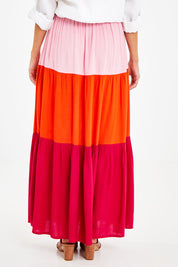 Model Courtney wearing size 10 of the Poppy Tier Skirt in colour Sunset (Pink), from the back