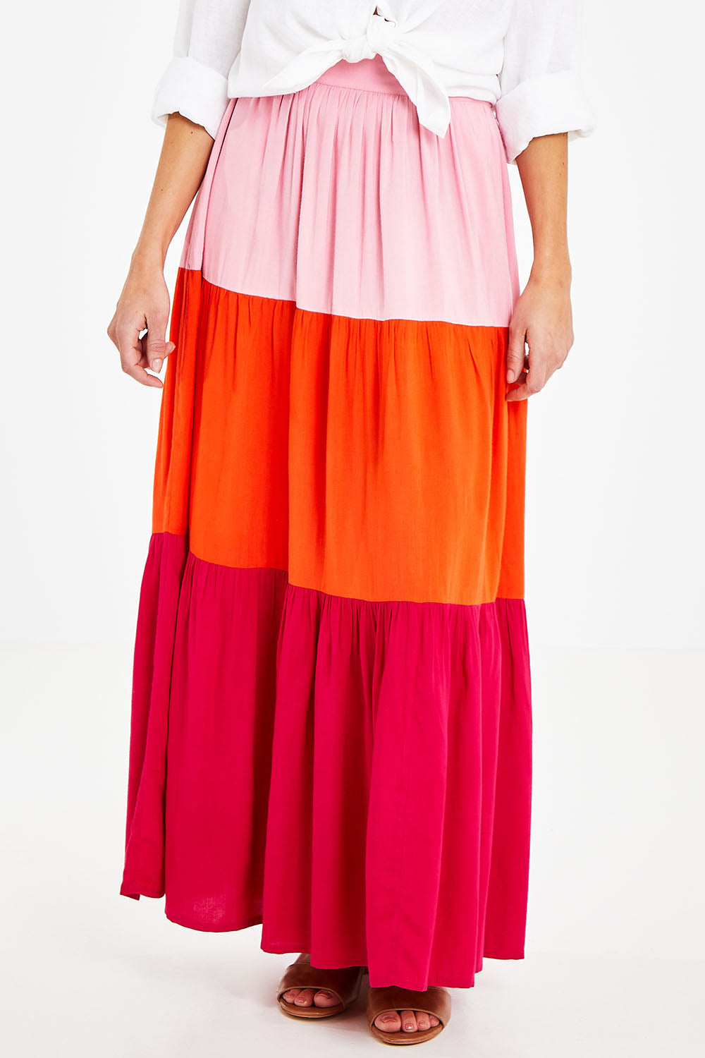 Model Courtney wearing size 10 of the Poppy Tier Skirt in colour Sunset (Pink), from the front, cropped image