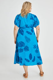 Model Keeara wearing size 16 of the Lucy Bell Sleeve Dress in colour Palm (Blue), from the back