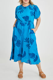 Model Keeara wearing size 16 of the Lucy Bell Sleeve Dress in colour Palm (Blue), from the front, cropped image