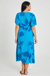 Model Terri-Leigh wearing size 14 of the Lucy Bell Sleeve Dress in colour Palm (Blue), from the back