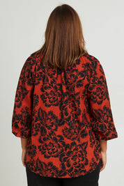 Model Monique wearing size 14 of the Jess Blouse in colour Blooming (Black), from the back
