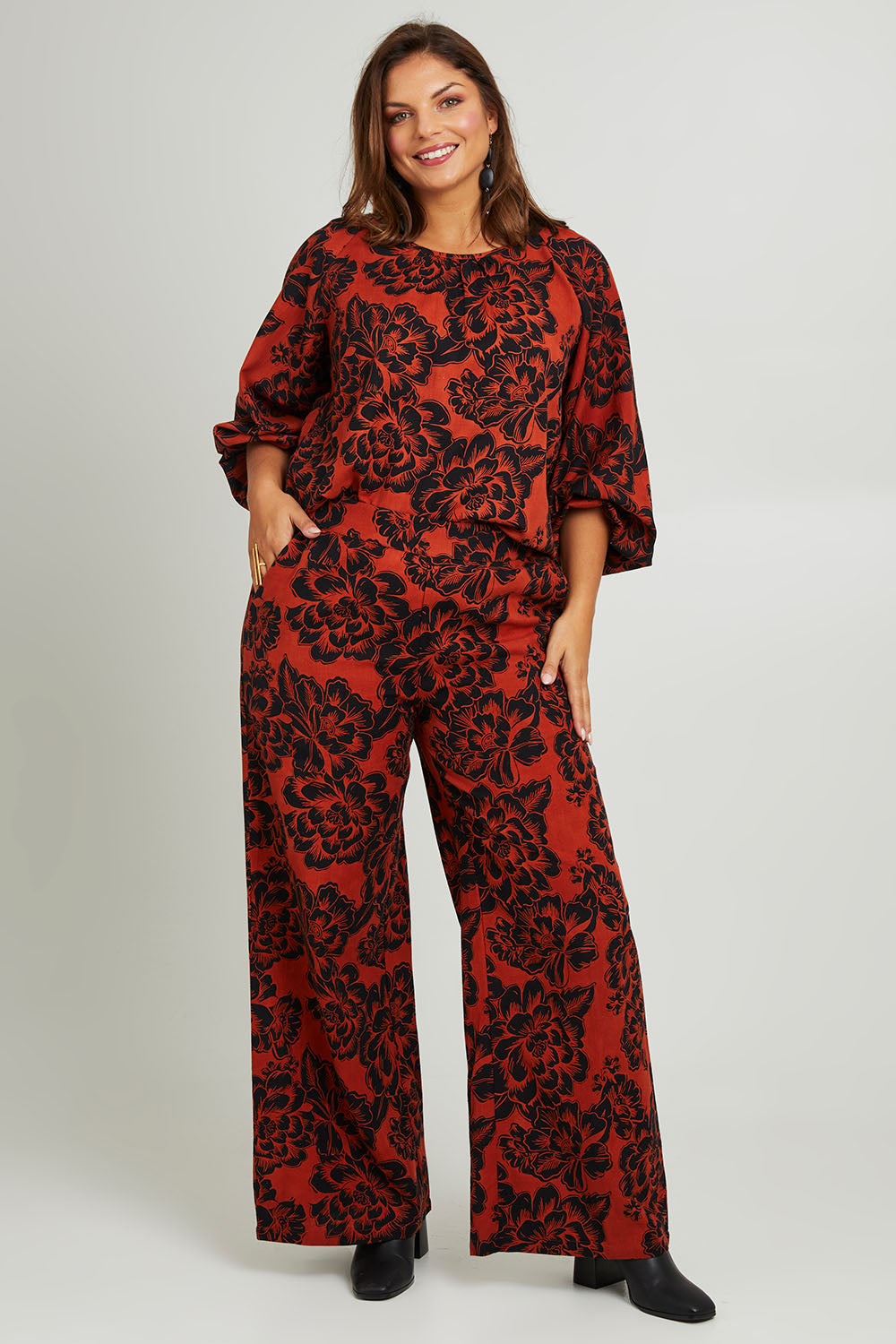 Model Monique wearing size 14 of the Jess Blouse in colour Blooming (Black), from the front, showing the whole outfit