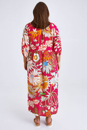 Model Monique wearing size 14 of the Isabella Dress in colour Garden (Pink), from the back