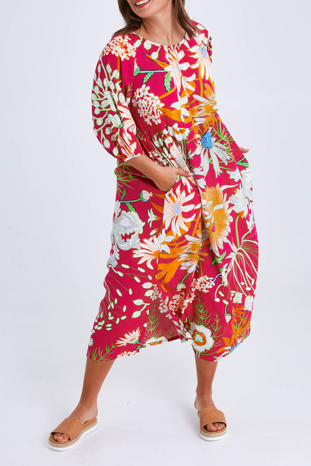 Model Monique wearing size 14 of the Isabella Dress in colour Garden (Pink), from the front, cropped image