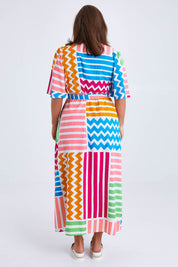 Model Monique wearing size 14 of the Ginerva Wrap Dress in colour Patchwork (White), from the back