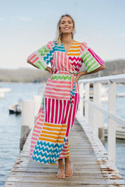 Model Phoebe wearing size 10 of the Ginerva Wrap Dress in colour Patchwork (White), from the front, showing the whole outfit