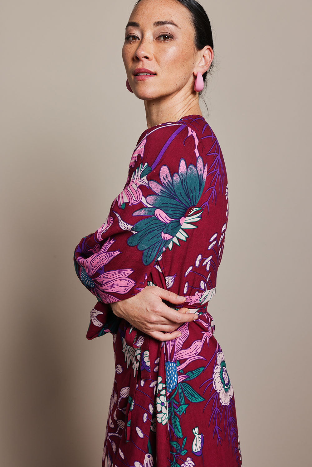 Model Katie wearing size 10 of the Daphne Maxi Wrap Dress in colour Garden, from the front, cropped image