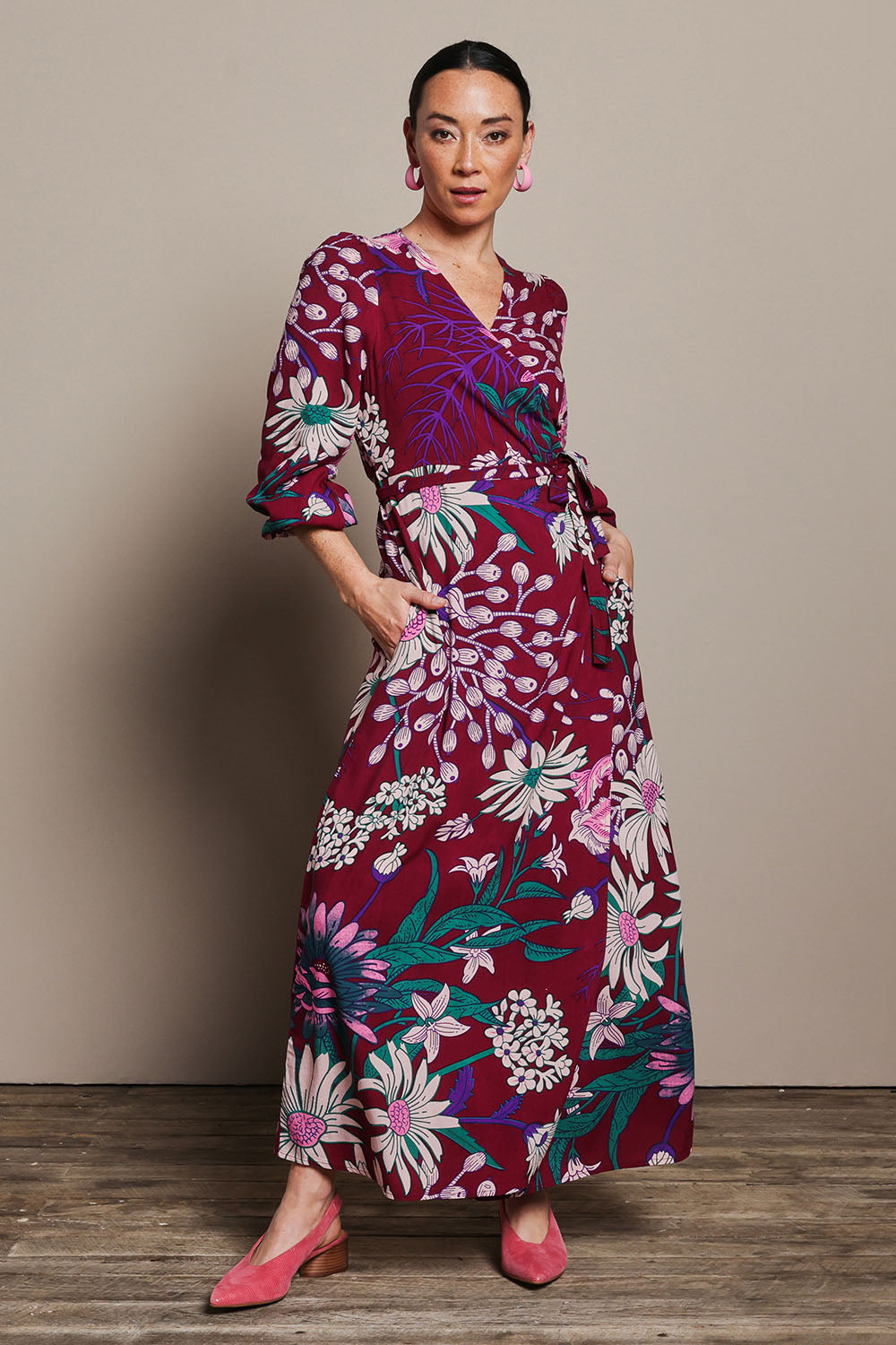 Model Katie wearing size 10 of the Daphne Maxi Wrap Dress in colour Garden, from the front, showing the whole outfit