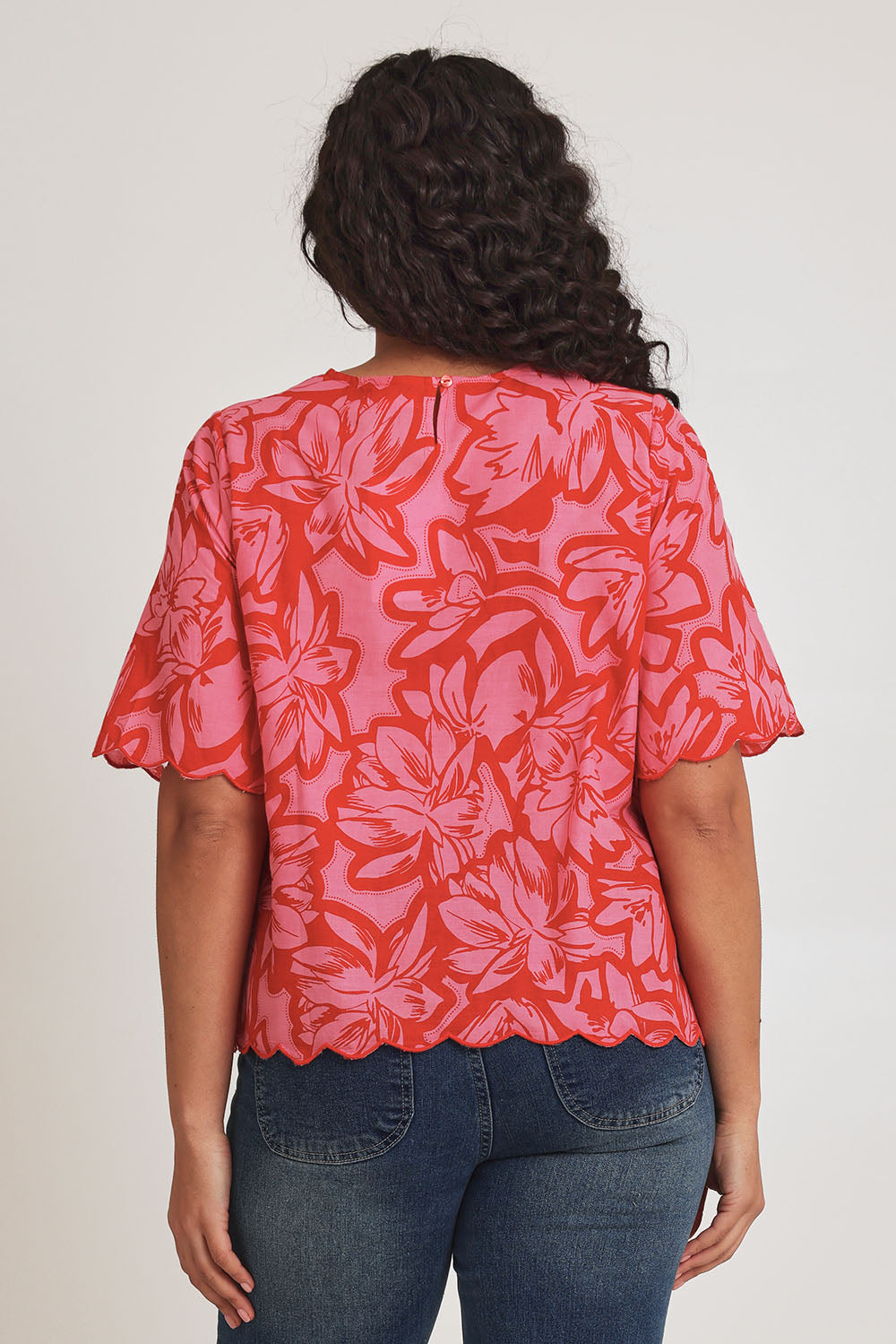 Model Terri-Leigh wearing size 14 of the Valentina Cotton Scalloped Hem Top in colour Flowerpop (Red), from the back