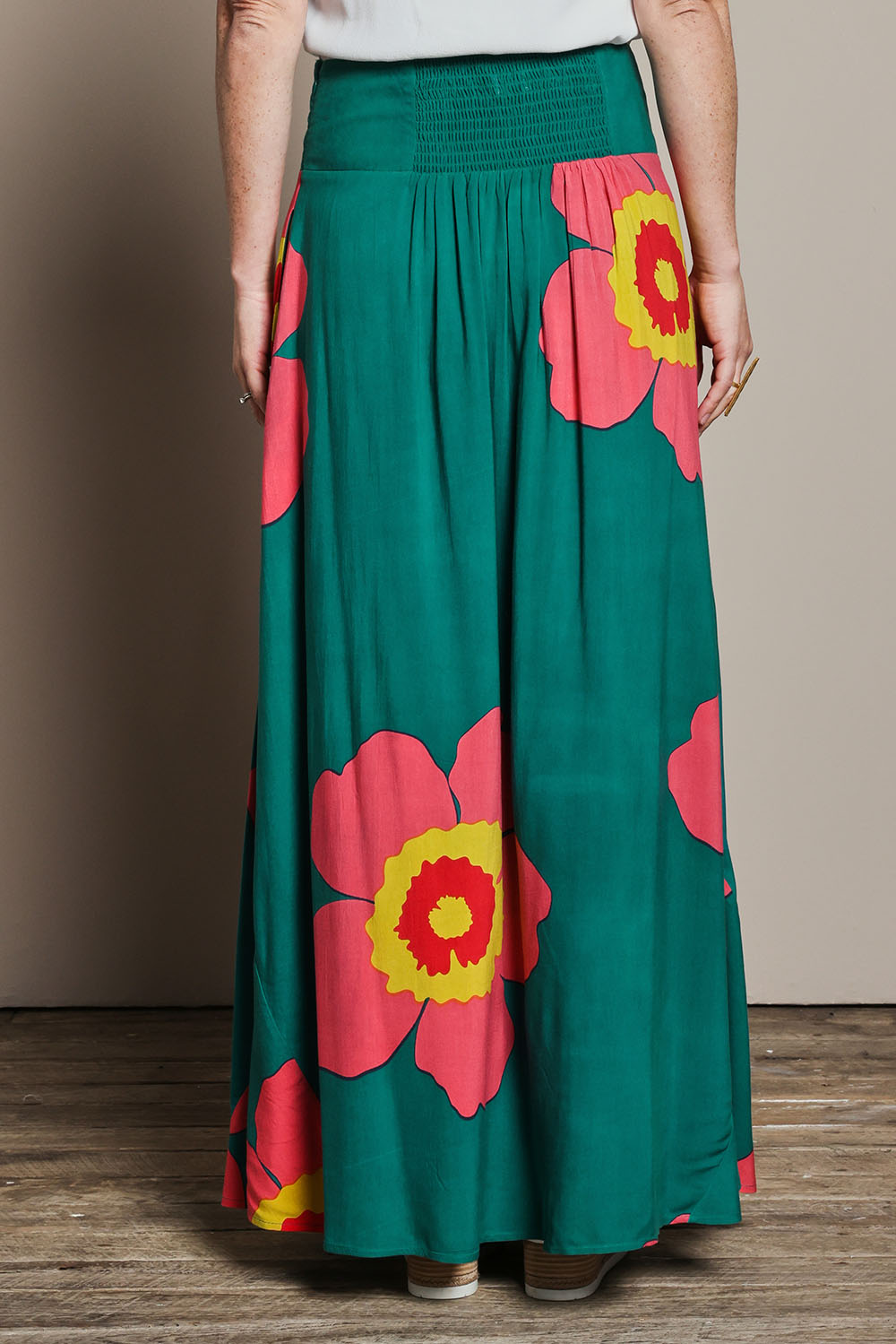 Model Katie wearing size 10 of the Rosie Maxi Skirt in colour Boldgreen (Green), from the back