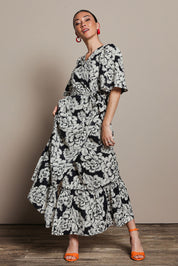 Model Katie wearing size 10 of the Anastasia Cotton Wrap Dress in colour Blooming (Black), from the front, showing the whole outfit