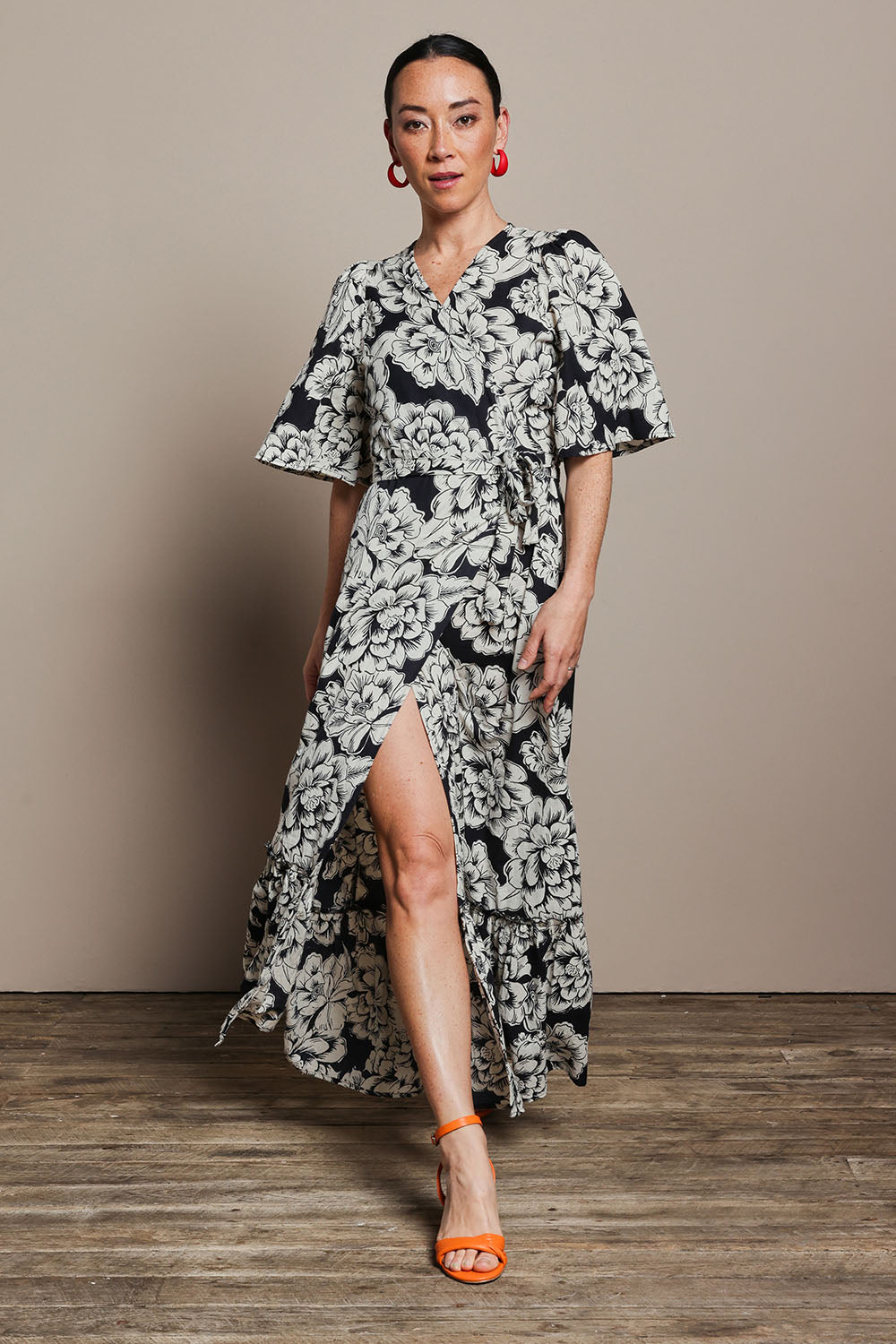 Model Katie wearing size 10 of the Anastasia Cotton Wrap Dress in colour Blooming (Black), from the front, showing the whole outfit