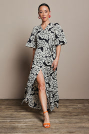Model Katie wearing size 10 of the Anastasia Cotton Wrap Dress in colour Blooming (Black), from the front, showing the whole outfit
