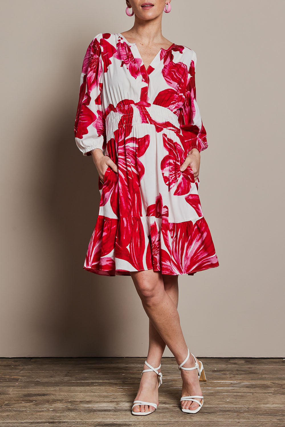 Model Katie wearing size 10 of the Gabrielle Dress in colour Lilly (Pink), from the front, cropped image
