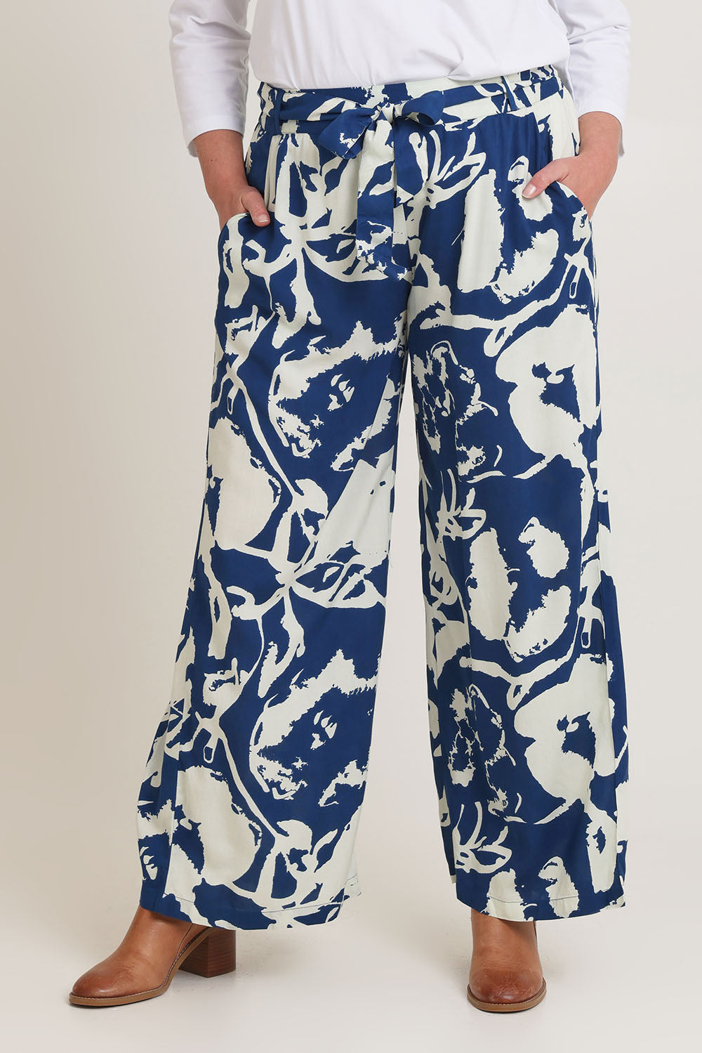 Model Chanel wearing size 16 of the Kayla Pant in colour Inkblot (Blue), from the front, cropped image