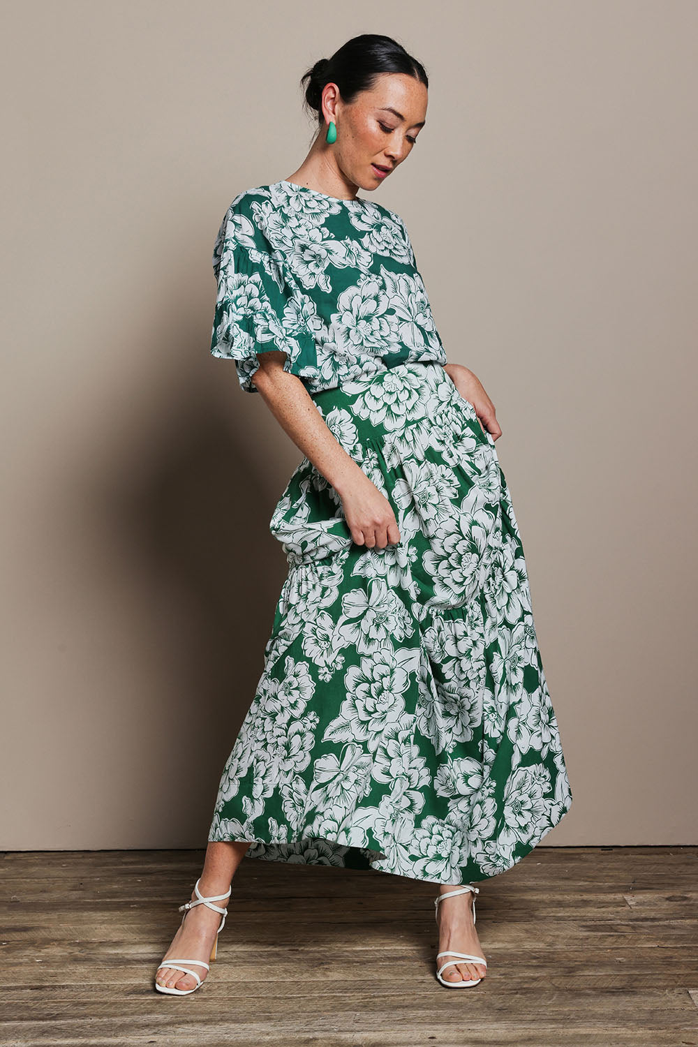 Model Katie wearing size 10 of the Ella Tiered Skirt in colour Blooming (Green), from the front, showing the whole outfit