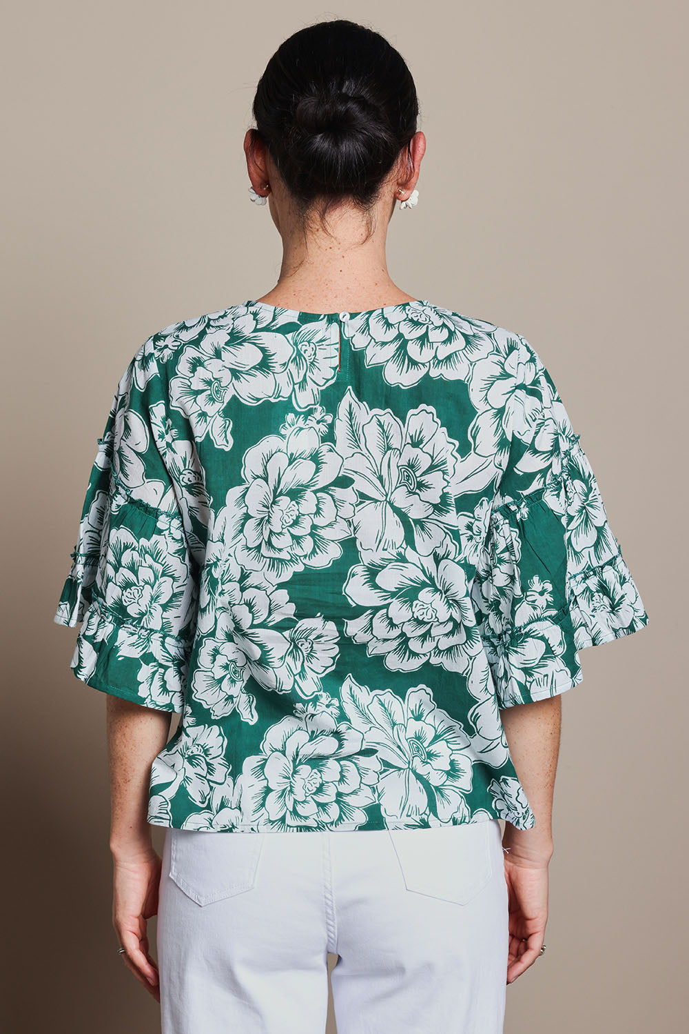 Model Tahnee wearing size 10 of the Kylie Frill Sleeve Cotton Top in colour Blooming (Green), from the back
