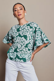 Model Tahnee wearing size 10 of the Kylie Frill Sleeve Cotton Top in colour Blooming (Green), from the front, cropped image