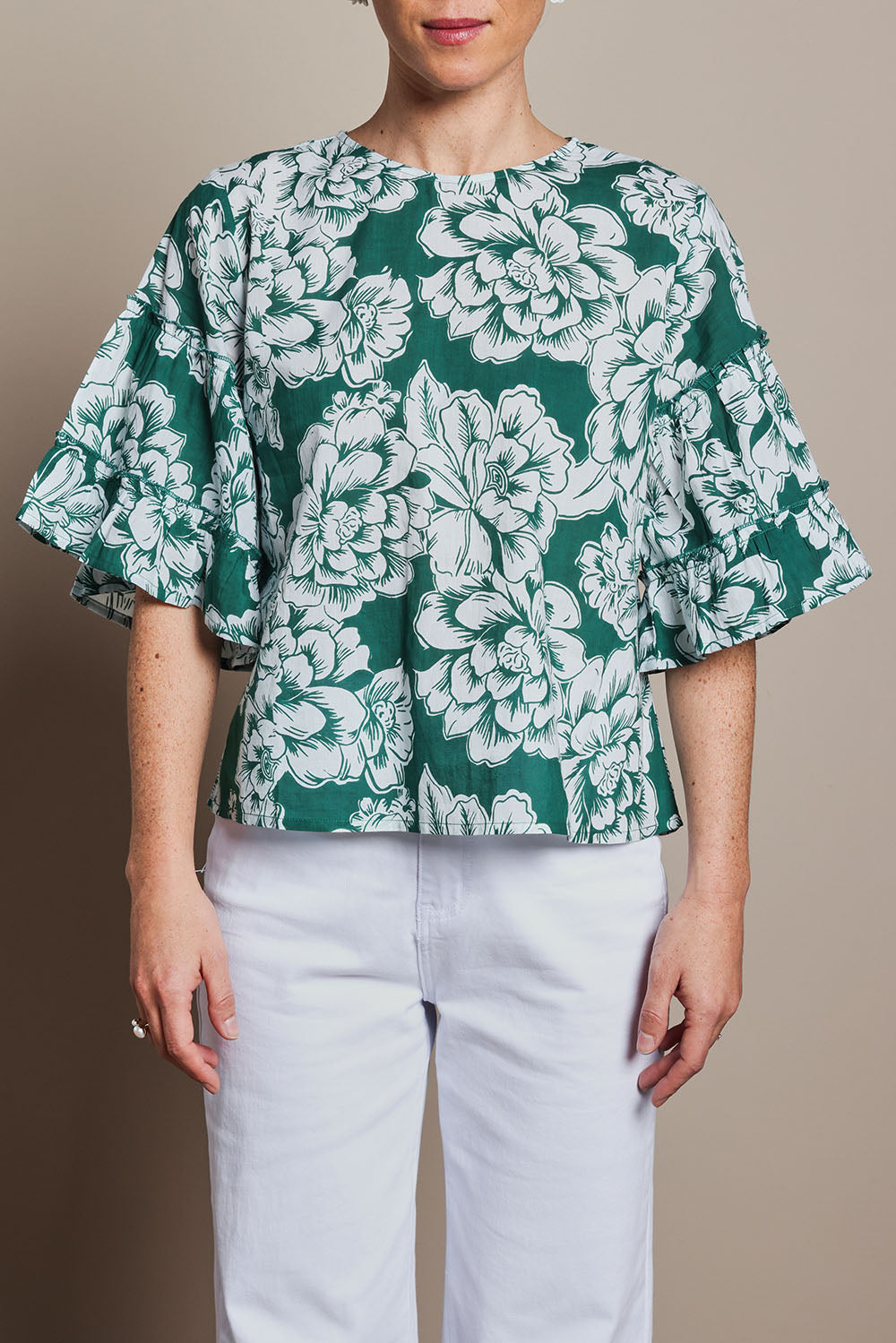 Model Tahnee wearing size 10 of the Kylie Frill Sleeve Cotton Top in colour Blooming (Green), from the front, cropped image