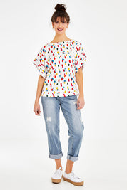 Model Courtney wearing size 10 of the Lola Belle Sleeve Top in colour Speckled (White), from the front, showing the whole outfit