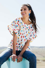 Model Vitoria wearing size 10 of the Lola Belle Sleeve Top in colour Speckled (White), from the front, showing the whole outfit