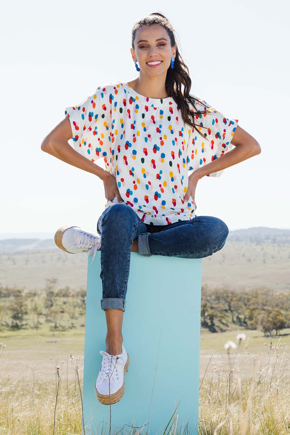 Model Vitoria wearing size 10 of the Lola Belle Sleeve Top in colour Speckled (White), from the front, showing the whole outfit