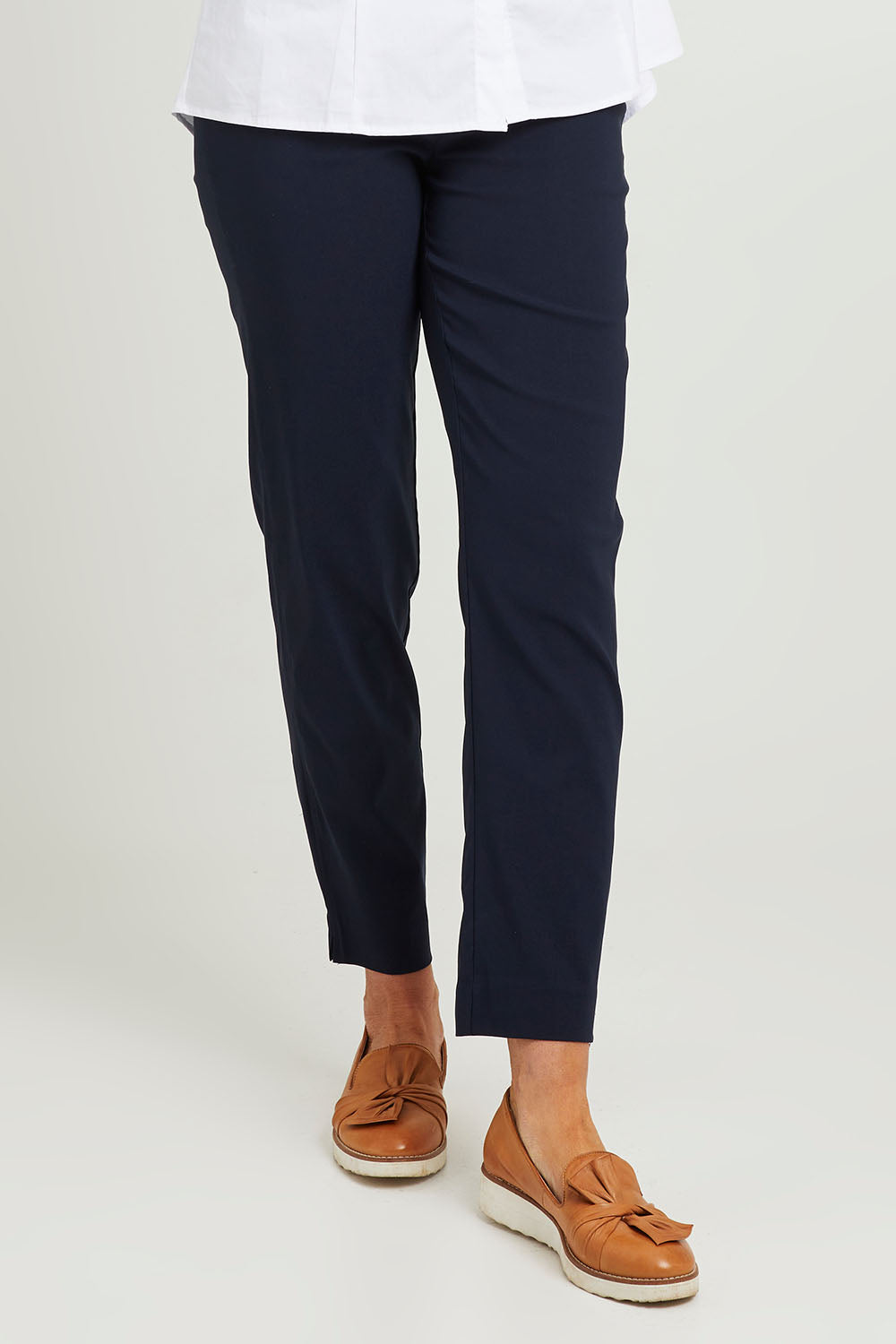 Model Emma wearing size S of the Pull On Pant in colour Navy (Blue), from the front, cropped image