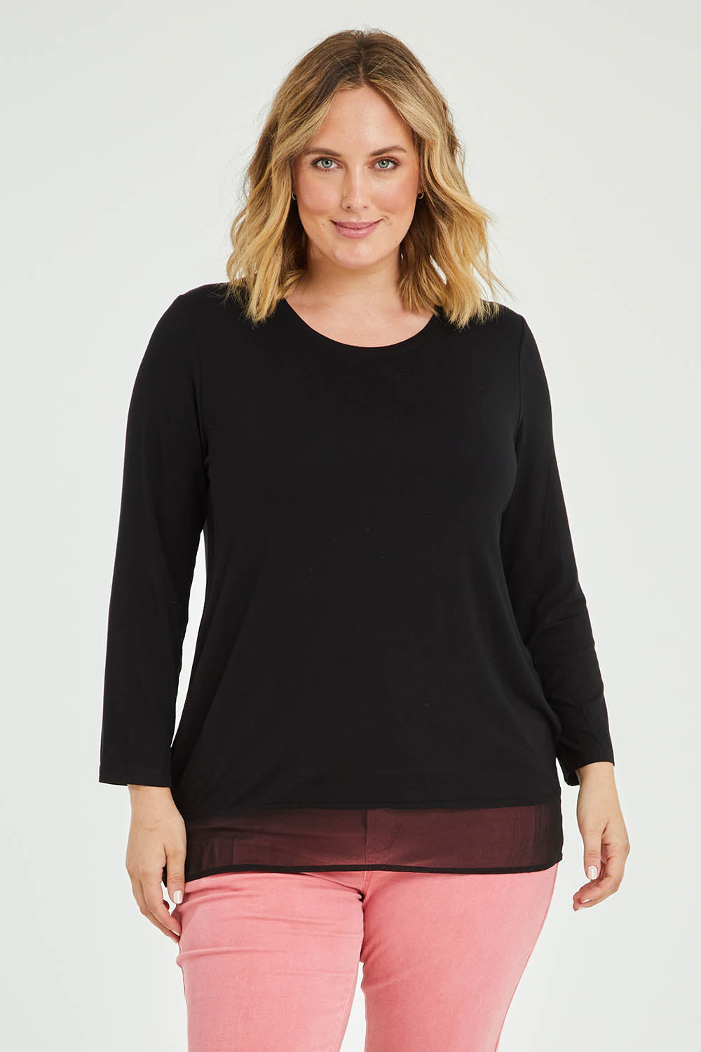 Model Jess wearing size L of the L/S Georgette Hem Top in colour Black (Black), from the front, cropped image