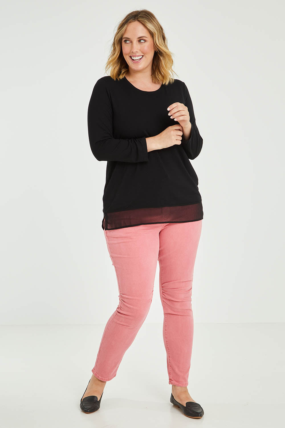 Model Jess wearing size L of the L/S Georgette Hem Top in colour Black (Black), from the front, showing the whole outfit