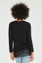 Model Olivia wearing size S of the L/S Georgette Hem Top in colour Black (Black), from the back
