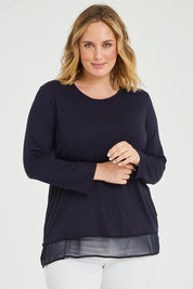 Model Jess wearing size L of the L/S Georgette Hem Top in colour Navy (Blue), from the front, cropped image