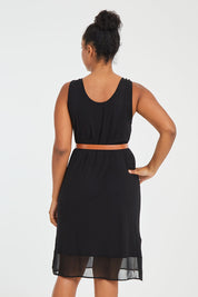 Model Noli wearing size L of the Reversible Essential Slip Dress in colour Black (Black), from the back