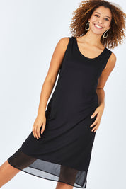 Model Summer wearing size S of the Reversible Essential Slip Dress in colour Black (Black), from the front, cropped image
