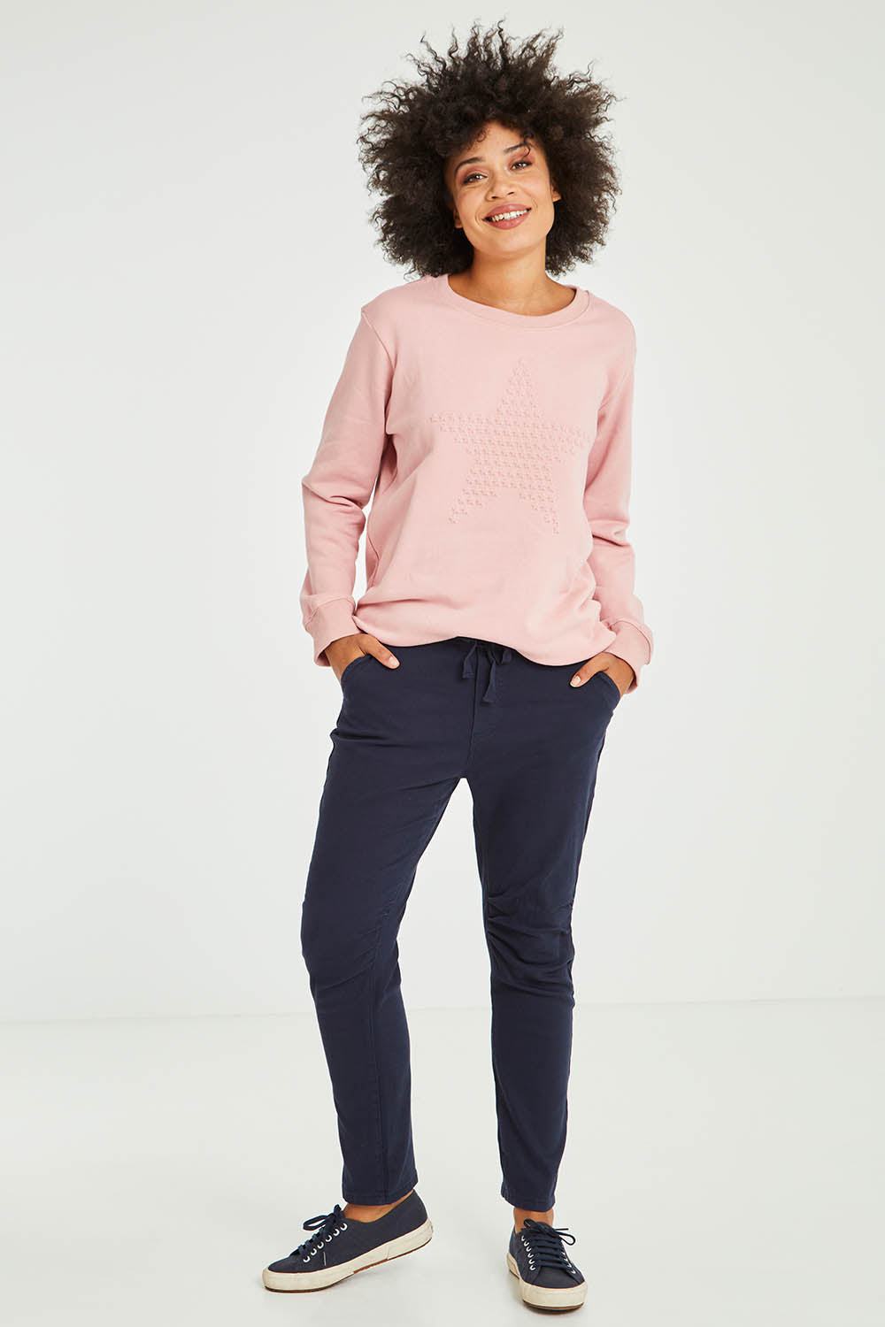 Model Olivia wearing size S of the Jogger Jean in colour Navy (Blue), from the front, showing the whole outfit