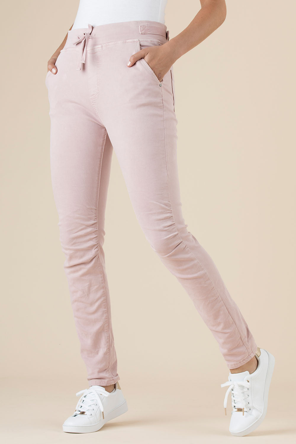 A model wearing the Jogger Jean in colour Pink (Pink), from the front, cropped image