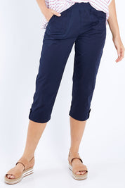 Model Madeline wearing size S of the Santorini Cotton Pant in colour Navy (Blue), from the front, cropped image
