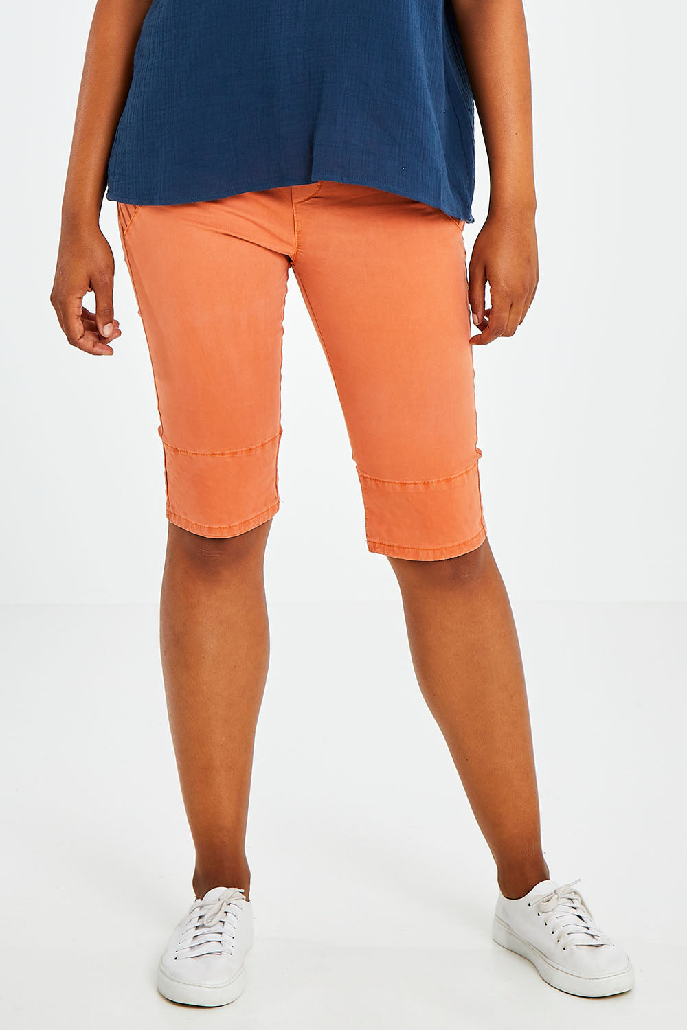 Model Olivia wearing size S of the Jogger Short in colour Orange, from the front, cropped image