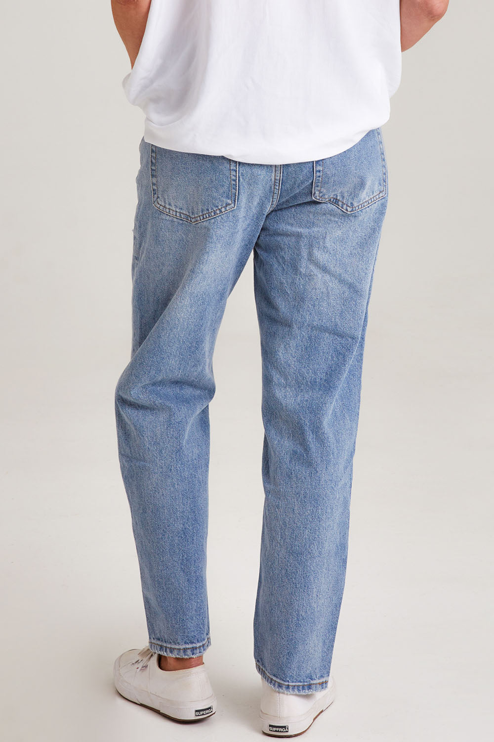 Model Emma wearing size S of the Ivy Mom Jean in colour Denim (Blue), from the back