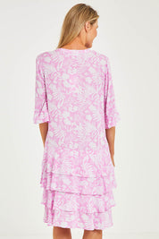 Model Kelly wearing size S of the Print Layered Dress in colour Lolly (Pink), from the back