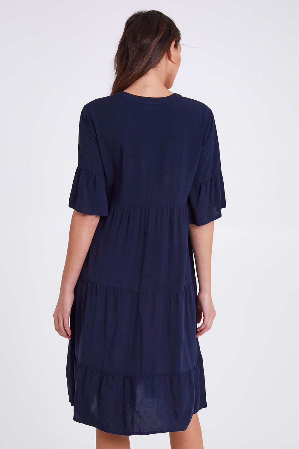 Model Madeline wearing size S of the Tier Swing Dress in colour Navy (Blue), from the back