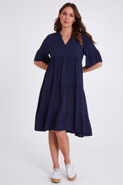 Model Madeline wearing size S of the Tier Swing Dress in colour Navy (Blue), from the front, showing the whole outfit