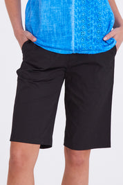 Model Madeline wearing size S of the Santorini Cotton Short in colour Black (Black), from the front, cropped image