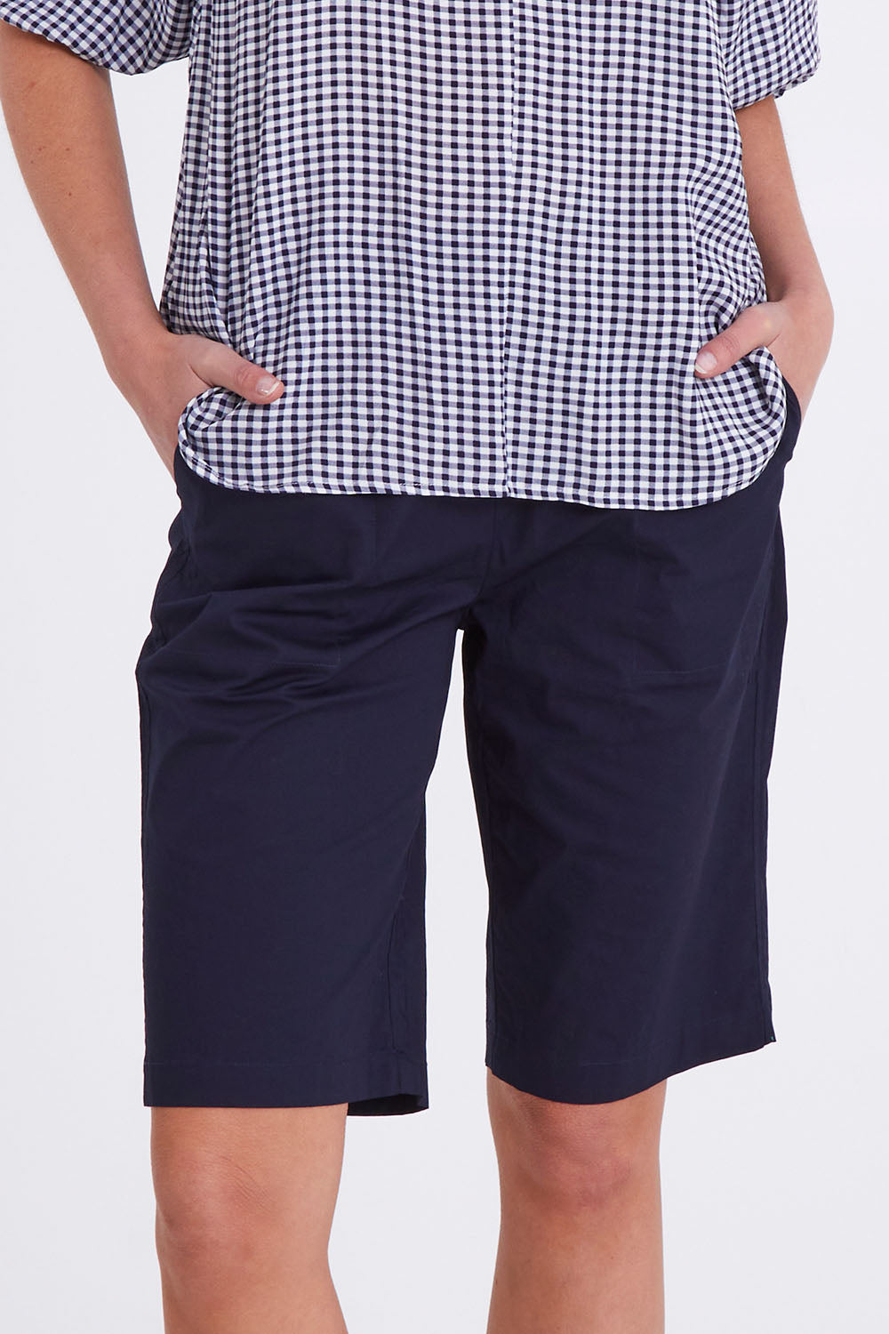 Model Madeline wearing size S of the Santorini Cotton Short in colour Navy (Blue), from the front, cropped image
