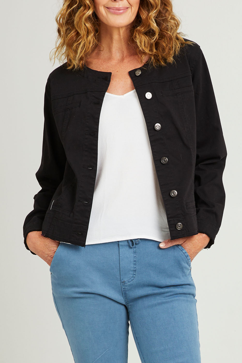 Model Emma wearing size S of the Collarless Denim Jacket in colour Black (Black), from the front, cropped image