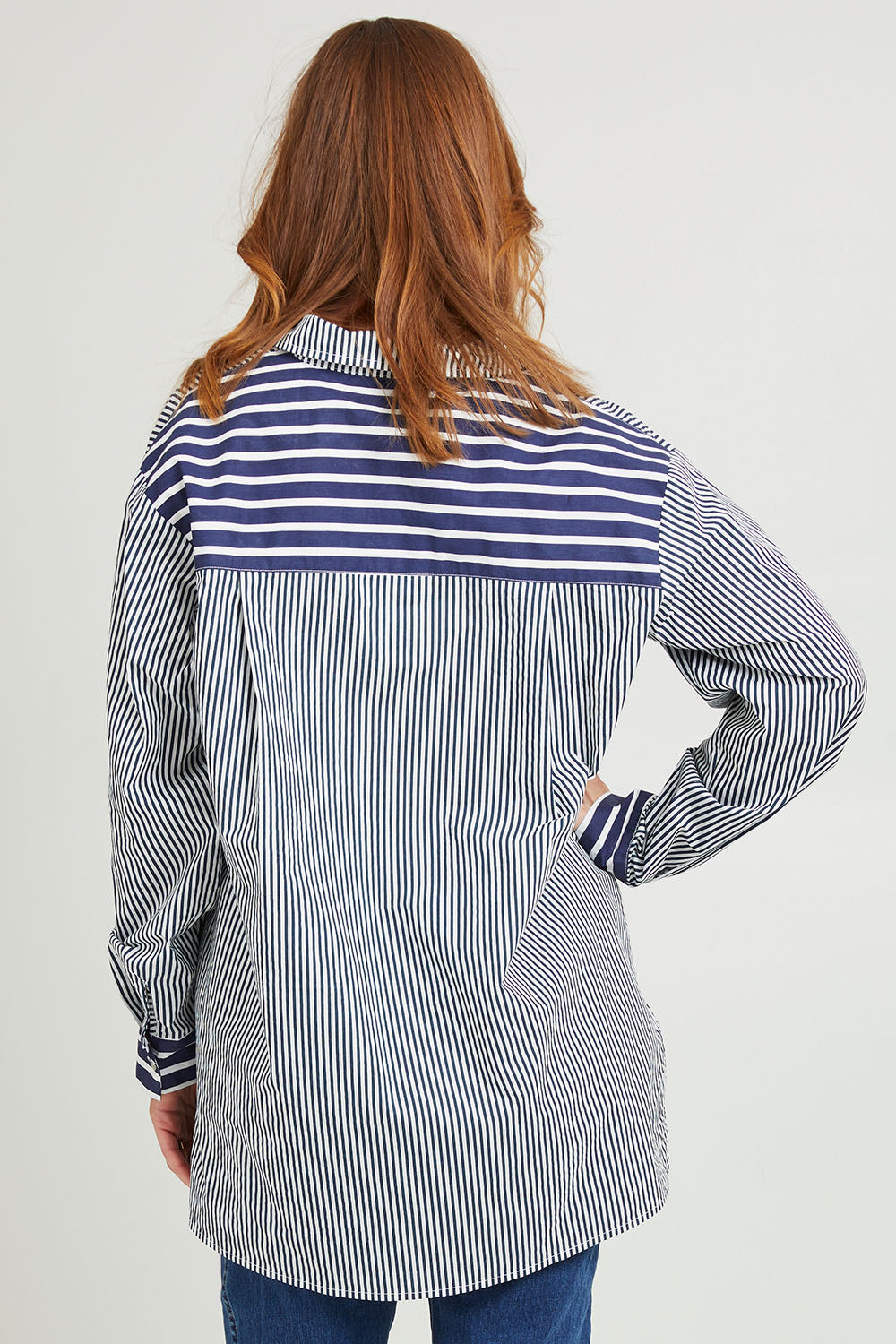 Model Katie wearing size S of the Anna Stripe Shirt in colour Navy (Blue), from the back