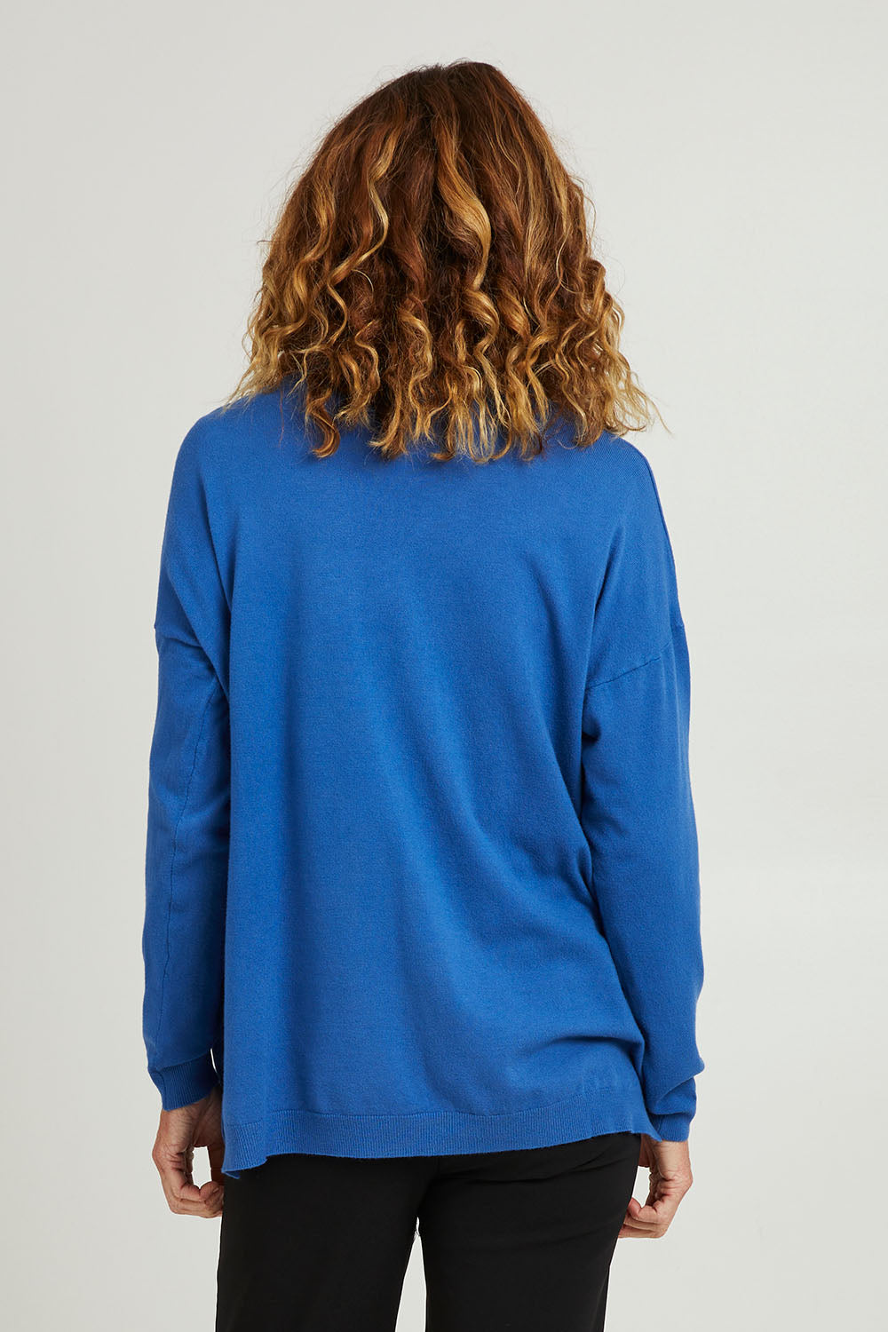 Model Emma wearing size S of the Cest La Vie Knit in colour Sapphire (Blue), from the back