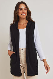 Model Madeline wearing size S of the Ollie Side Button Knit Vest in colour Black (Black), from the front, cropped image