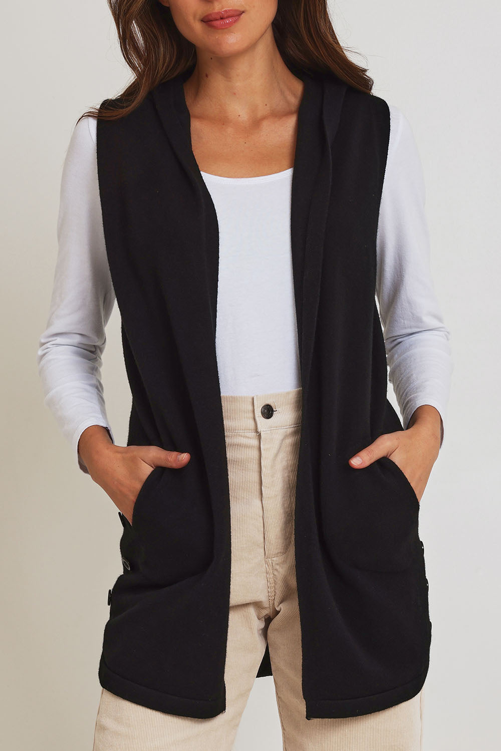 Model Madeline wearing size S of the Ollie Side Button Knit Vest in colour Black (Black), from the front, cropped image
