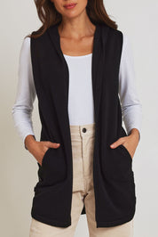 Model Madeline wearing size S of the Ollie Side Button Knit Vest in colour Black (Black), from the front, cropped image